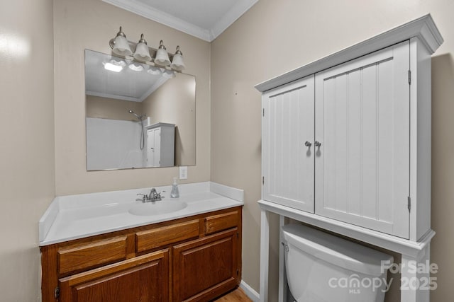 bathroom with vanity, toilet, ornamental molding, and walk in shower