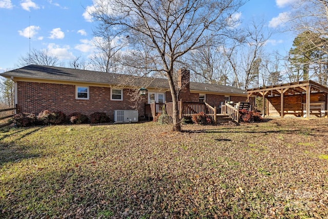 back of property with a lawn, central AC, a carport, and a deck