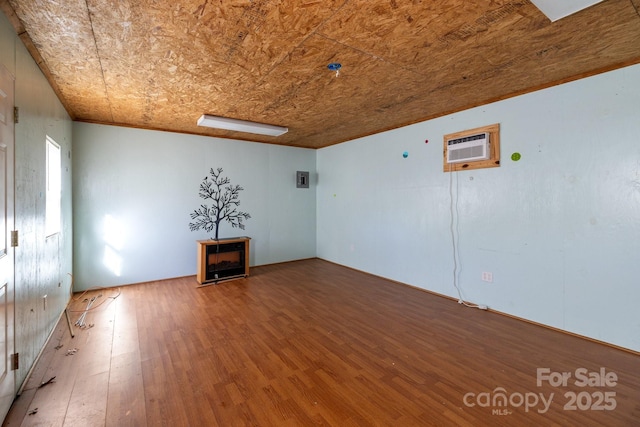 spare room with an AC wall unit, hardwood / wood-style floors, and wood ceiling