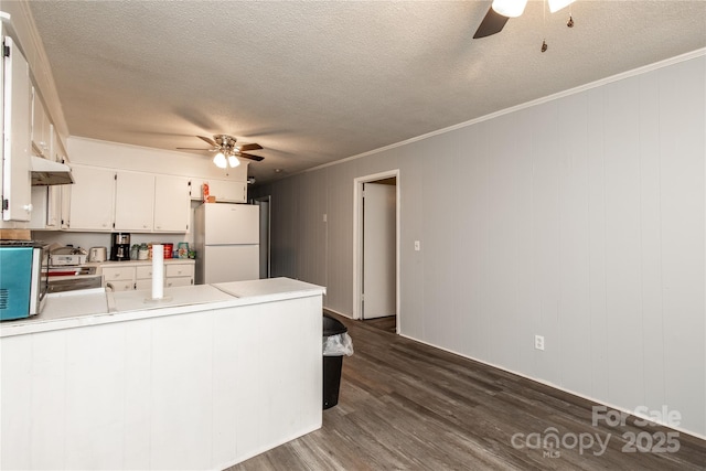 kitchen with freestanding refrigerator, ceiling fan, dark wood-type flooring, light countertops, and white cabinetry