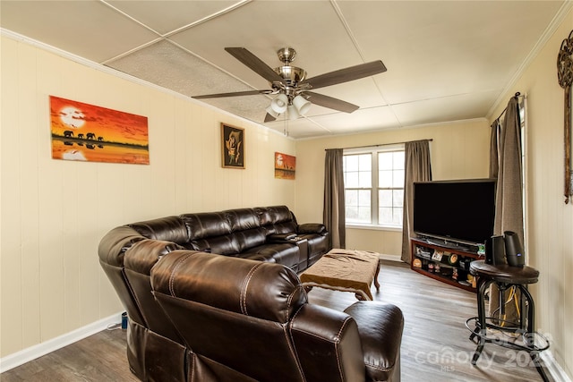 living area featuring baseboards, a ceiling fan, dark wood-style floors, and crown molding