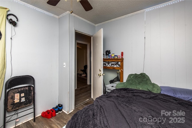 bedroom with a textured ceiling, wood finished floors, a ceiling fan, and ornamental molding