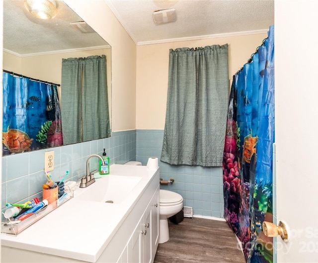 bathroom featuring vanity, wood finished floors, ornamental molding, a textured ceiling, and toilet