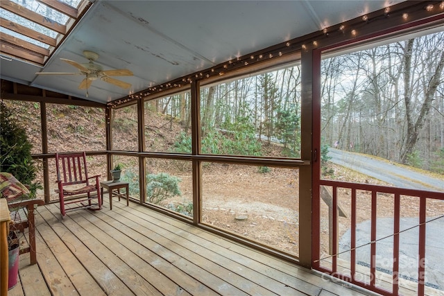 unfurnished sunroom featuring ceiling fan and a skylight