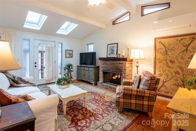 living room with vaulted ceiling with beams, a wall mounted air conditioner, a brick fireplace, a wealth of natural light, and hardwood / wood-style floors