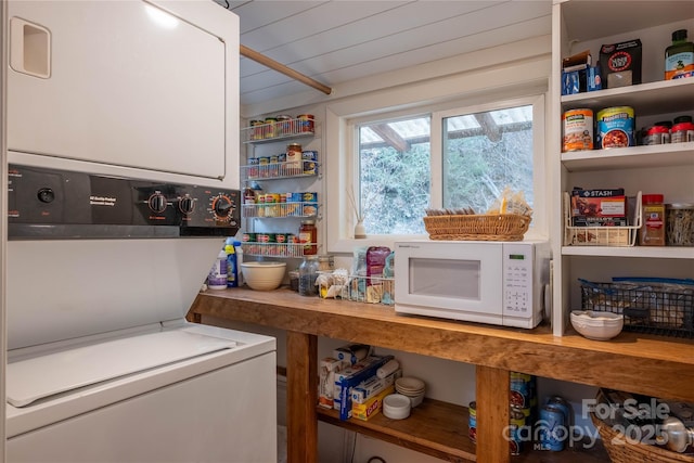 clothes washing area featuring stacked washer and dryer