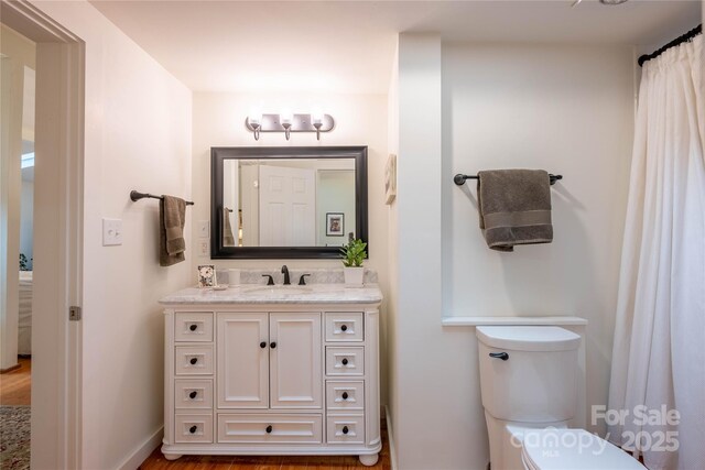 bathroom featuring hardwood / wood-style flooring, vanity, and toilet