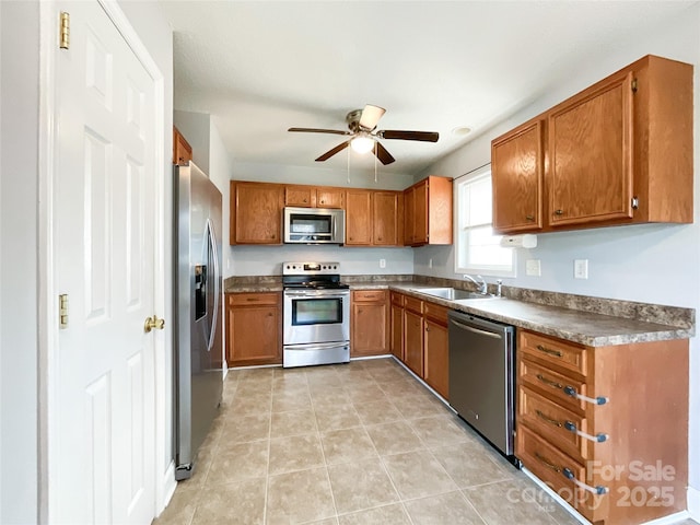 kitchen with appliances with stainless steel finishes, ceiling fan, light tile patterned floors, and sink