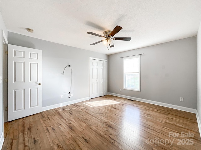 unfurnished bedroom with a closet, ceiling fan, a textured ceiling, and light hardwood / wood-style flooring