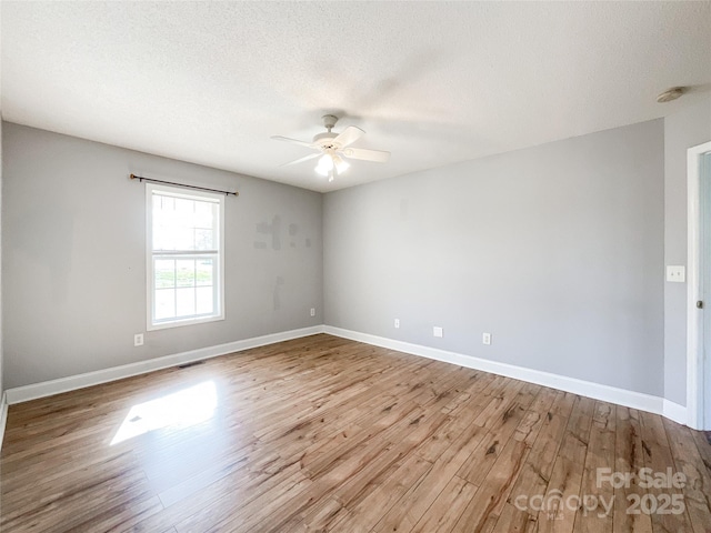 empty room featuring a textured ceiling, ceiling fan, and light hardwood / wood-style flooring