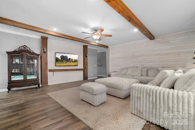 living room featuring ceiling fan, wood walls, beamed ceiling, and hardwood / wood-style flooring