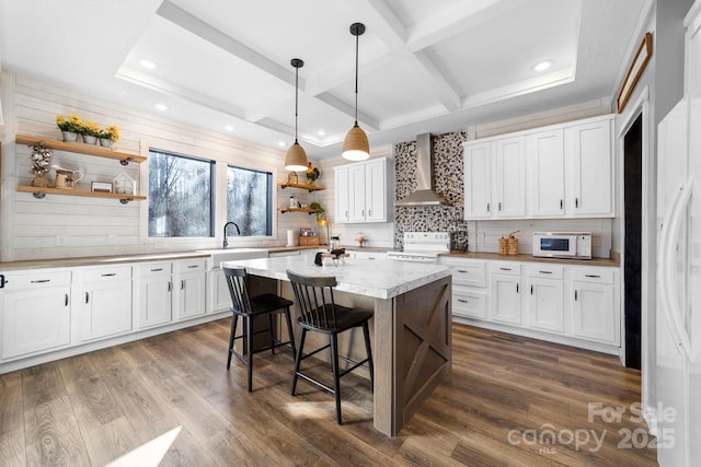 kitchen featuring white cabinets and wall chimney range hood