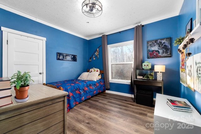 bedroom featuring a textured ceiling, crown molding, and dark hardwood / wood-style floors