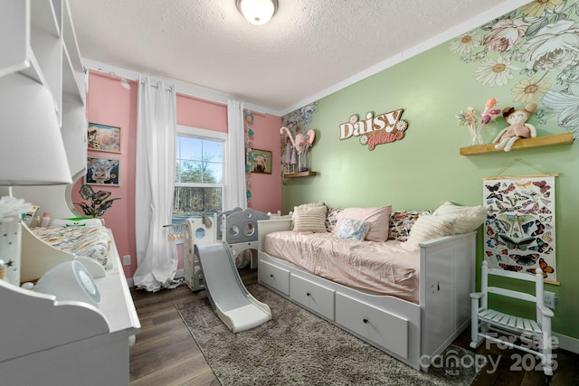 bedroom featuring dark wood-type flooring, a textured ceiling, and ornamental molding