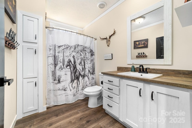 bathroom featuring a textured ceiling, ornamental molding, wood-type flooring, and vanity