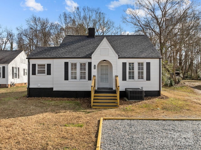 view of front of property with central air condition unit and a front yard