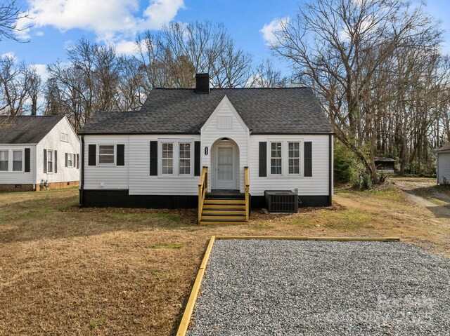 view of front of property with central air condition unit and a front lawn