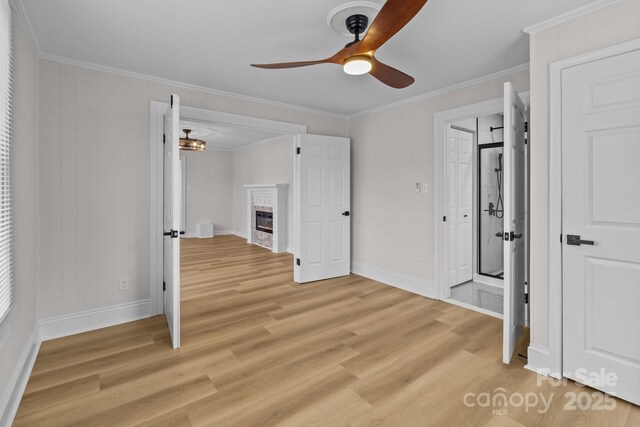 spare room featuring light wood-type flooring, ceiling fan, and crown molding