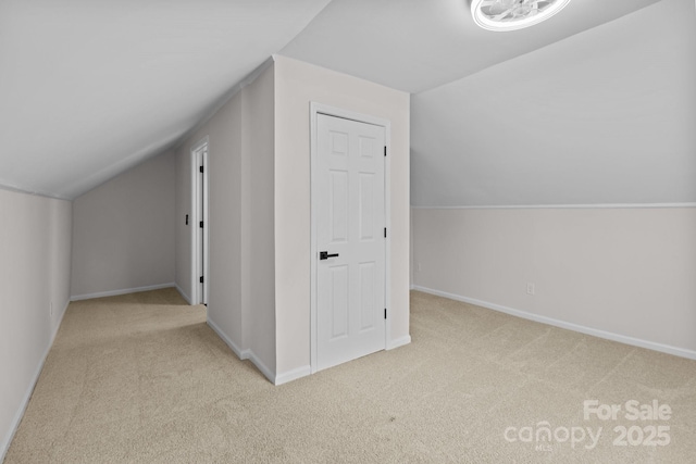 additional living space featuring lofted ceiling and light carpet