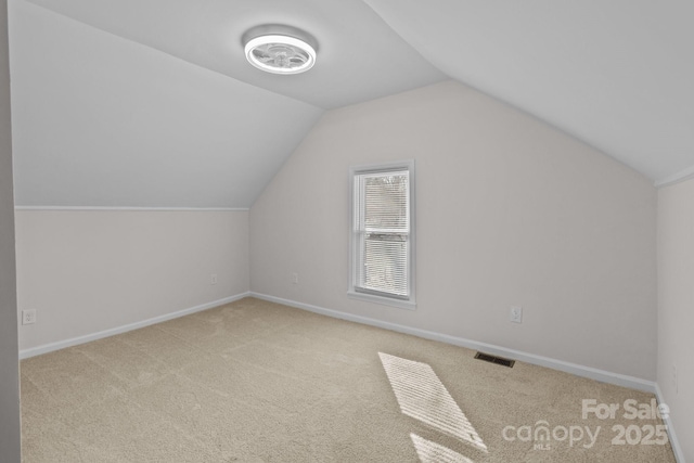 bonus room with light colored carpet and lofted ceiling