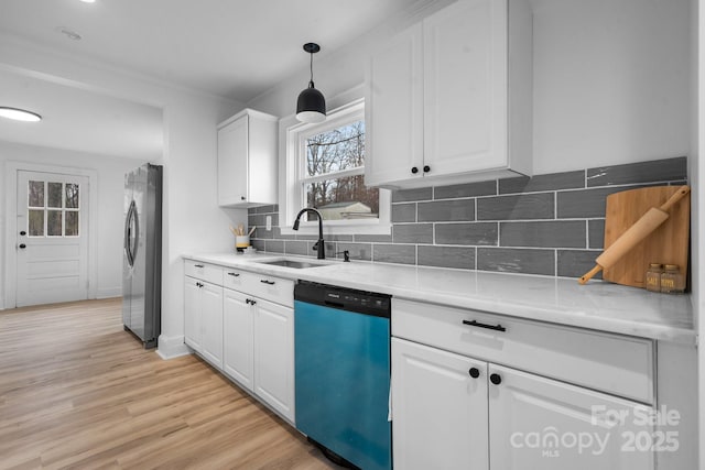 kitchen featuring decorative backsplash, stainless steel appliances, sink, white cabinets, and hanging light fixtures