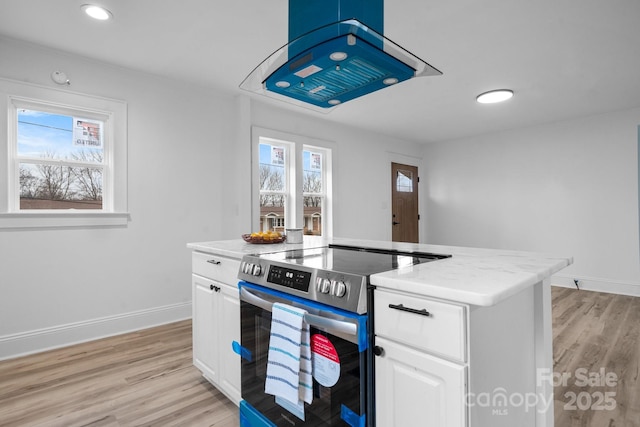 kitchen featuring white cabinetry, a center island, light stone countertops, stainless steel range with electric cooktop, and light wood-type flooring