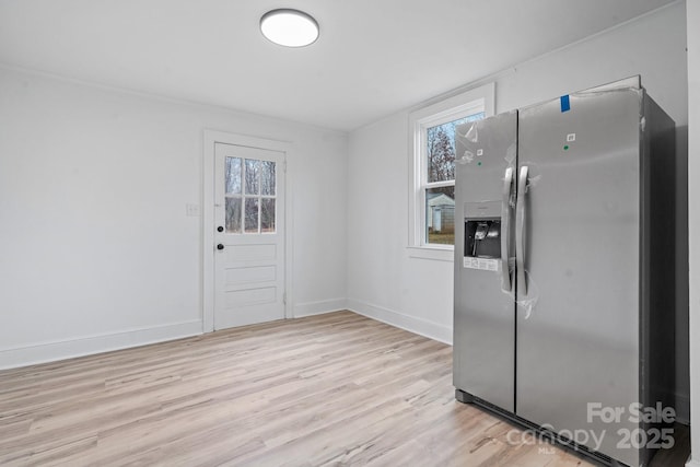 kitchen with stainless steel fridge with ice dispenser and light wood-type flooring