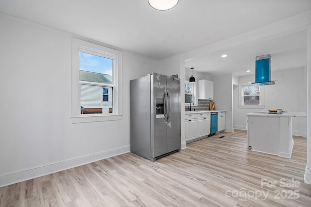 kitchen featuring white cabinets, sink, stainless steel fridge, dishwashing machine, and light hardwood / wood-style floors