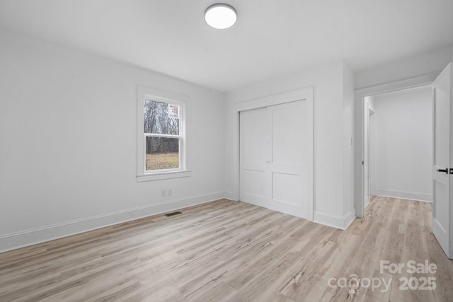 unfurnished bedroom featuring light hardwood / wood-style floors and a closet