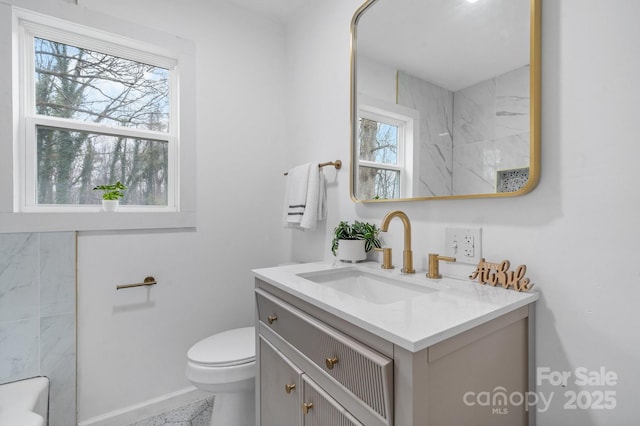 bathroom with vanity, toilet, and plenty of natural light