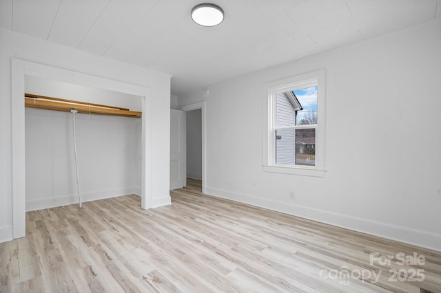 unfurnished bedroom with light hardwood / wood-style flooring and a closet