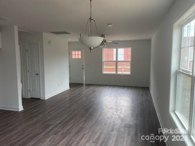 unfurnished dining area featuring ceiling fan and dark hardwood / wood-style floors