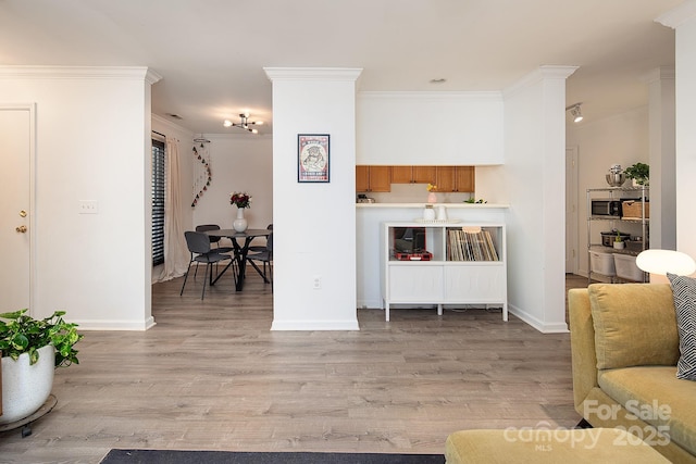 living room with ornamental molding and light hardwood / wood-style flooring