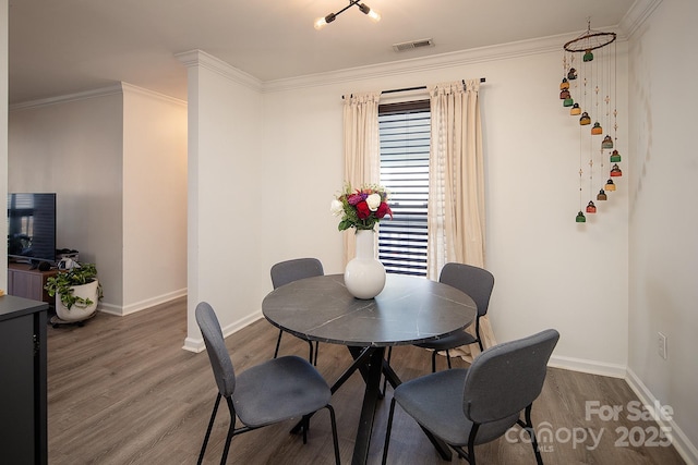 dining space featuring ornamental molding and hardwood / wood-style floors