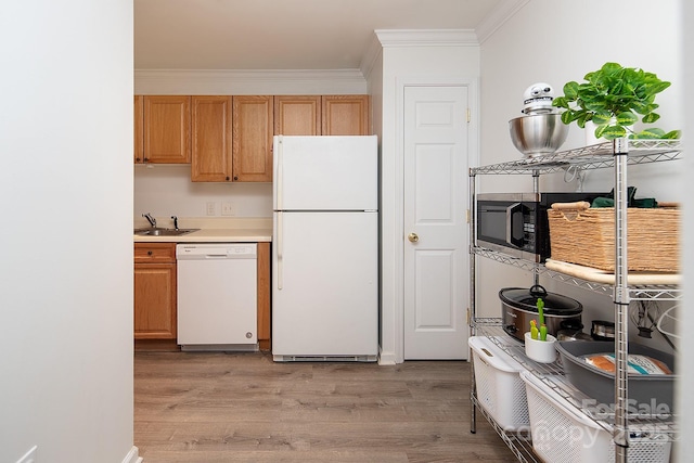 kitchen with sink, white appliances, ornamental molding, and light wood-type flooring