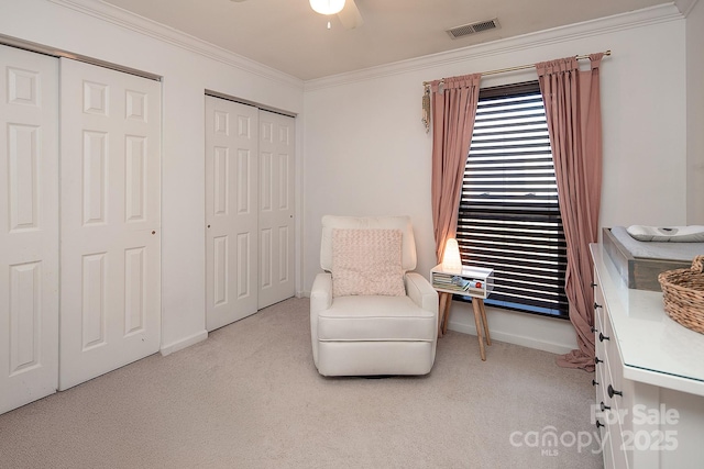 sitting room with ornamental molding, light colored carpet, and ceiling fan