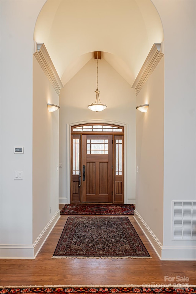 foyer featuring hardwood / wood-style floors and vaulted ceiling