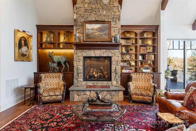 living area with vaulted ceiling, a fireplace, and wood-type flooring