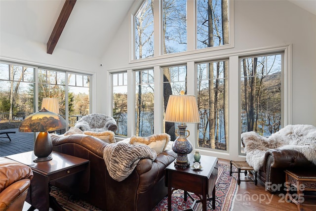 sunroom featuring beamed ceiling and a healthy amount of sunlight