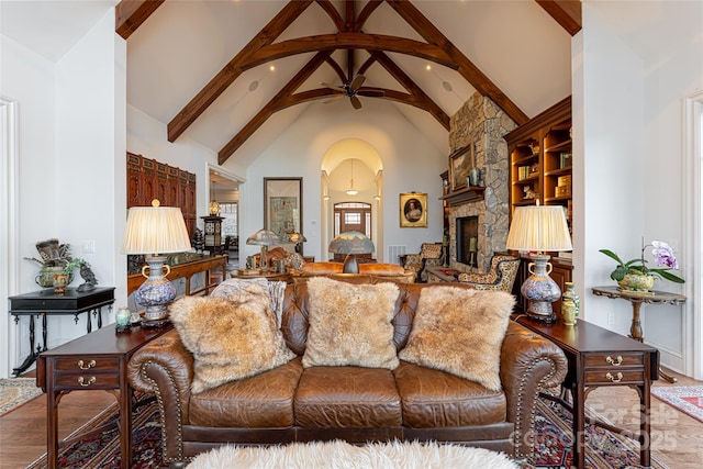 living room with a fireplace, beamed ceiling, hardwood / wood-style floors, ceiling fan, and high vaulted ceiling