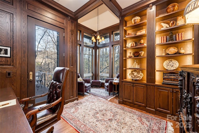 office area featuring built in shelves, an inviting chandelier, a wealth of natural light, and crown molding