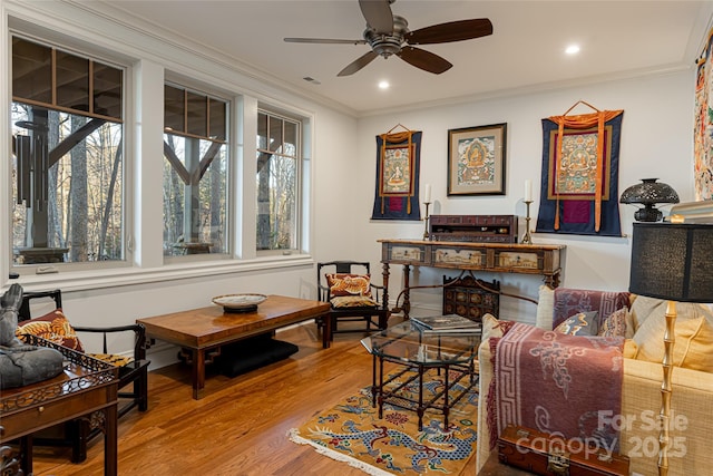 living room featuring ornamental molding, ceiling fan, and hardwood / wood-style flooring