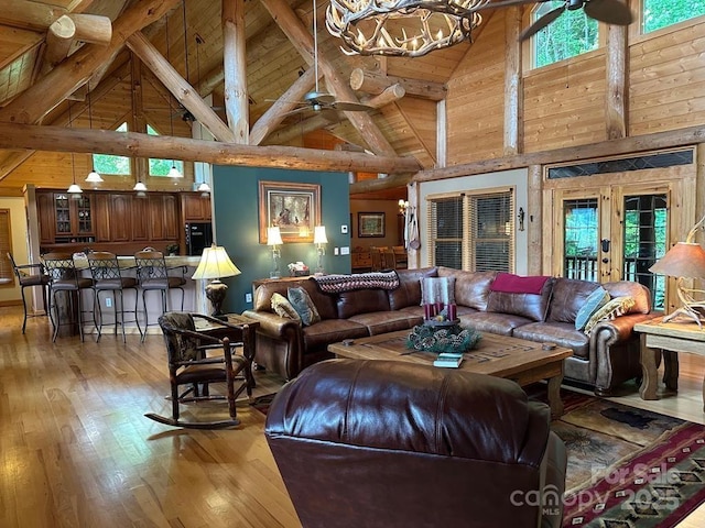 living room featuring beamed ceiling, wooden ceiling, high vaulted ceiling, and an inviting chandelier