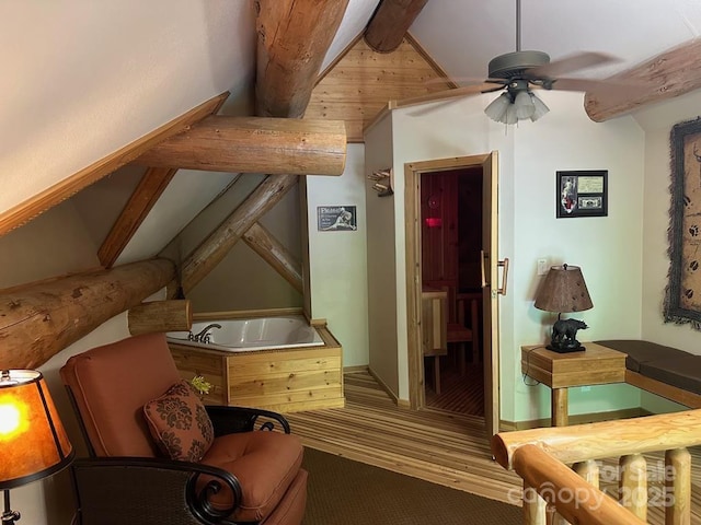 sitting room with ceiling fan and lofted ceiling with beams