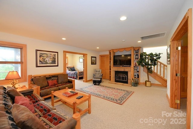 living room with carpet floors and a tile fireplace