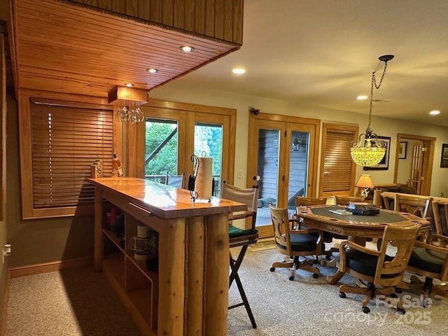 carpeted dining room featuring french doors and wood ceiling