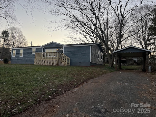 view of front of home with a carport and a yard