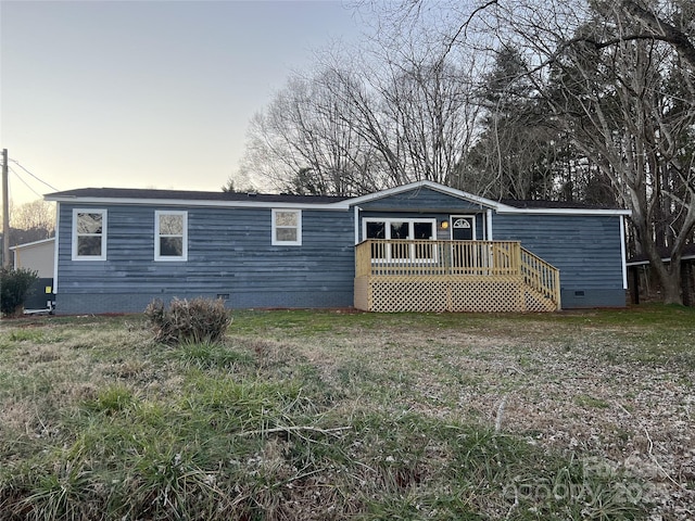 back house at dusk with a wooden deck