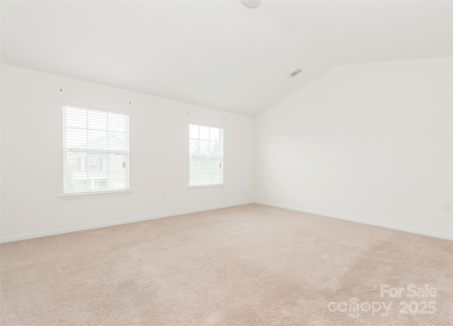 unfurnished room with vaulted ceiling and light colored carpet