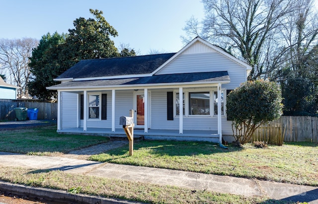 bungalow-style home with covered porch and a front lawn